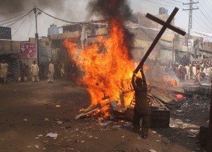 A demonstrator burns a cross during a protest in the Badami Bagh area of Lahore March 9, 2013. An enraged mob torched dozens of houses located in a Christian-dominated neighbourhood of Lahore on Saturday, local media reported. REUTERS/Adrees Hassain